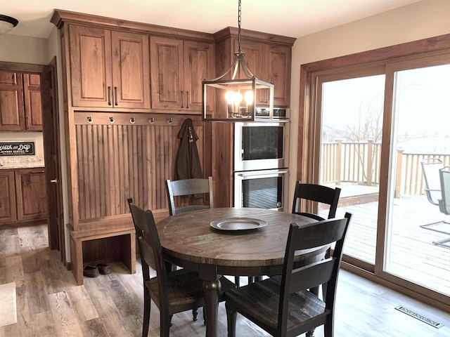 dining area with an inviting chandelier and light hardwood / wood-style floors