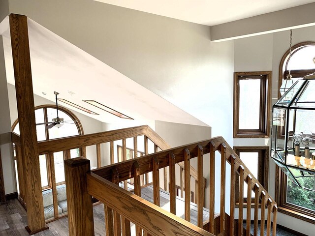 stairs featuring lofted ceiling, hardwood / wood-style flooring, and ceiling fan
