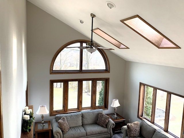 living room featuring lofted ceiling with skylight and ceiling fan