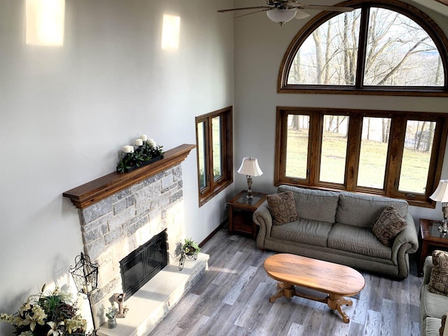 living room with ceiling fan, hardwood / wood-style floors, and a fireplace