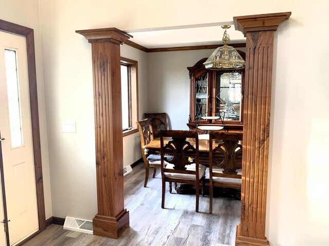 dining space featuring dark hardwood / wood-style flooring and ornate columns