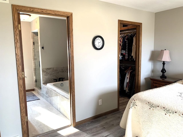 bedroom featuring wood-type flooring, a spacious closet, and a closet