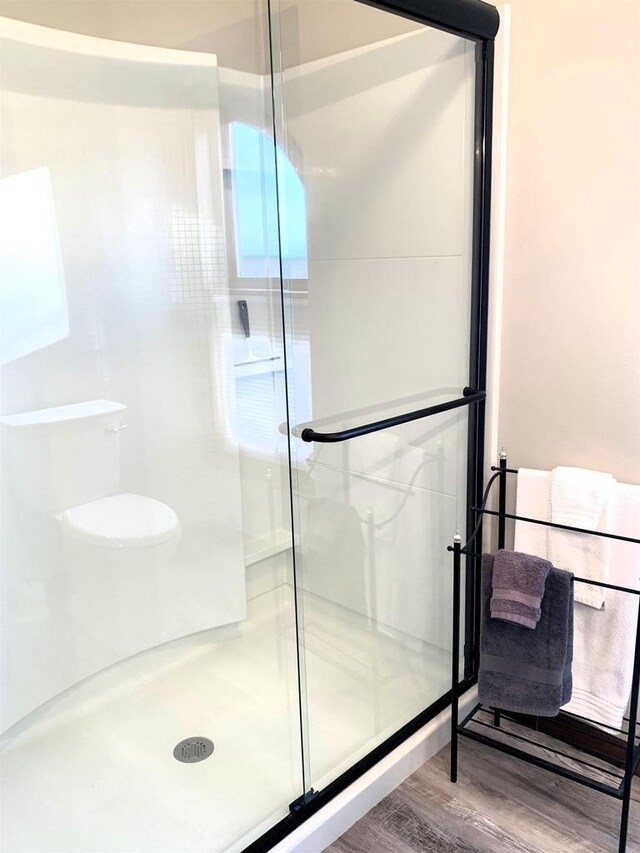 bathroom featuring hardwood / wood-style flooring and walk in shower