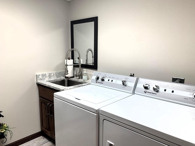 washroom with cabinets, separate washer and dryer, and sink