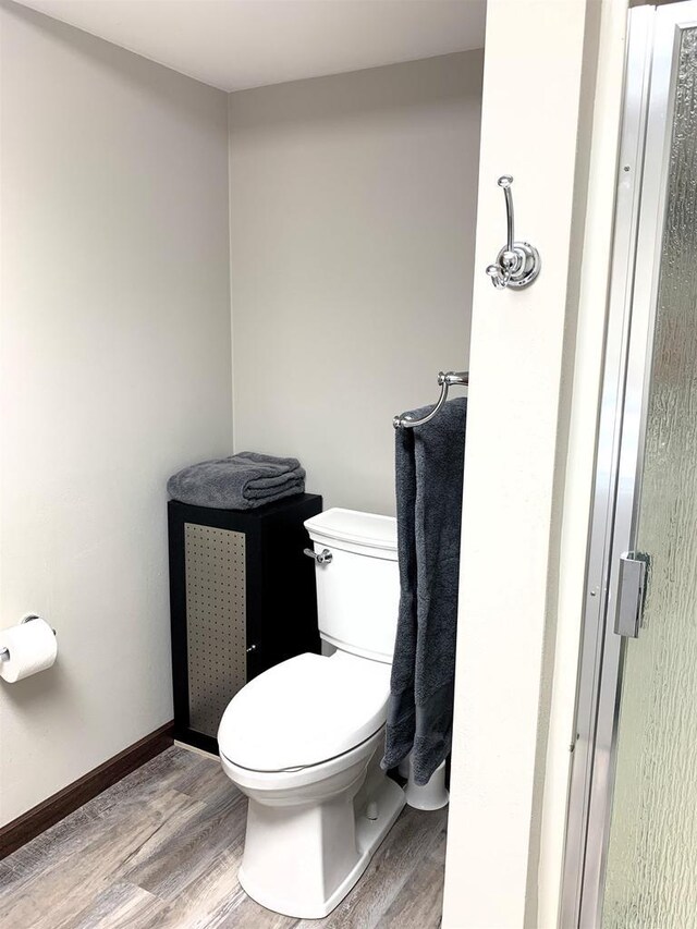 bathroom with toilet and hardwood / wood-style floors