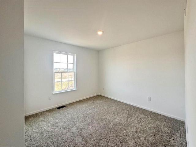 carpeted spare room featuring baseboards and visible vents