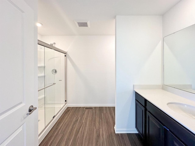 full bath featuring baseboards, visible vents, wood finished floors, vanity, and a shower stall