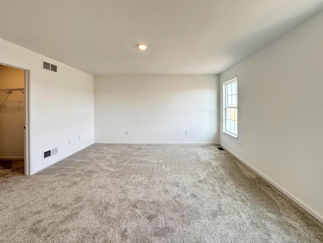 unfurnished room featuring carpet floors, baseboards, and visible vents