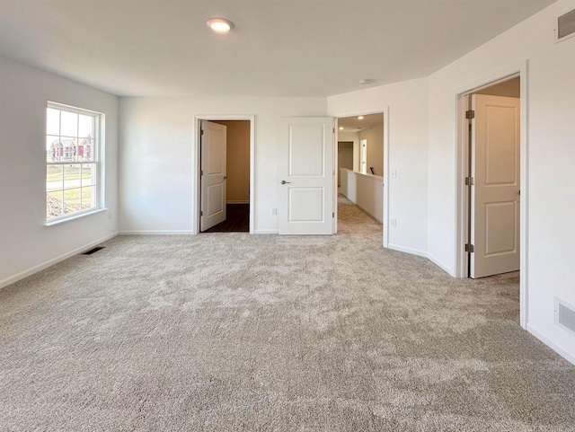 unfurnished bedroom featuring carpet, visible vents, and baseboards