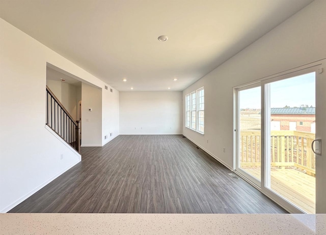 interior space with dark wood-style floors, recessed lighting, stairs, and baseboards