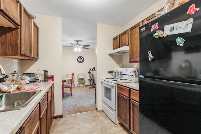 kitchen with black refrigerator, white electric stove, sink, ceiling fan, and light carpet