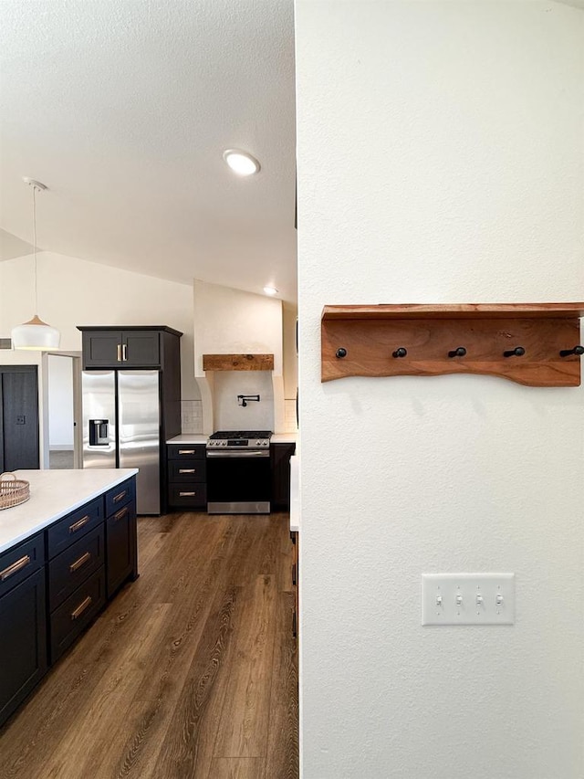 kitchen featuring pendant lighting, backsplash, dark wood-type flooring, and appliances with stainless steel finishes