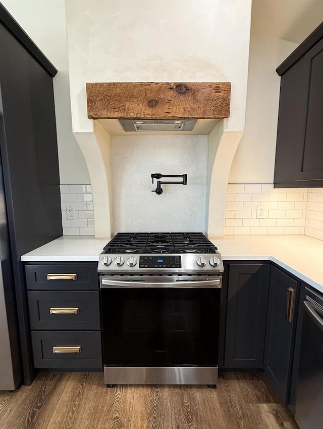 kitchen featuring premium range hood, appliances with stainless steel finishes, backsplash, and dark hardwood / wood-style flooring