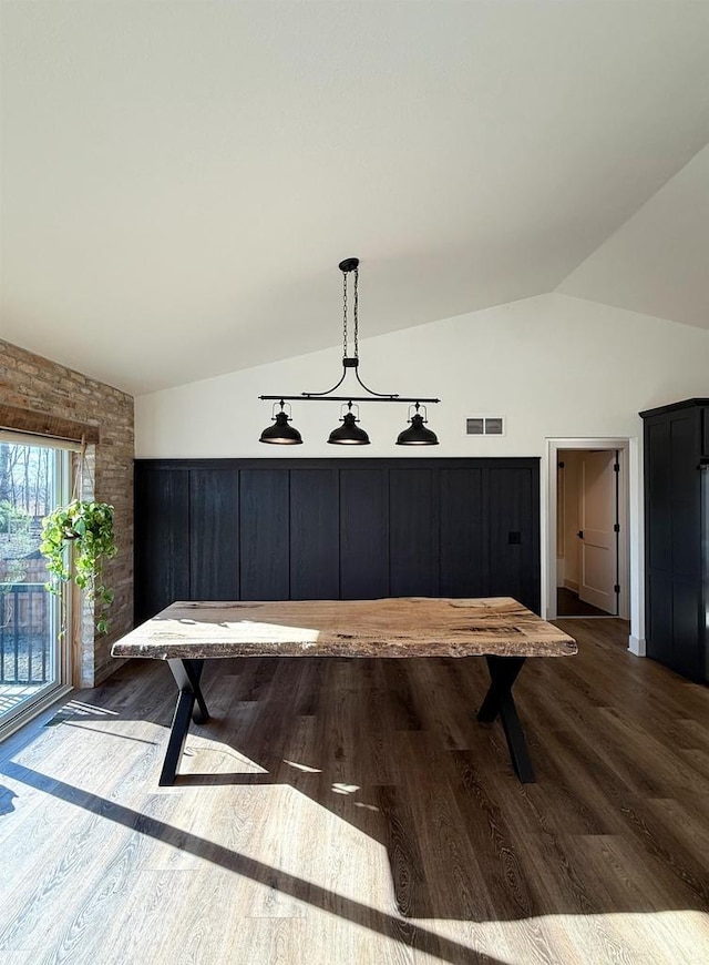 dining room featuring vaulted ceiling and dark hardwood / wood-style floors