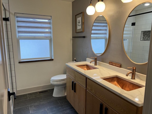 bathroom with vanity, a wealth of natural light, a shower with shower door, and toilet