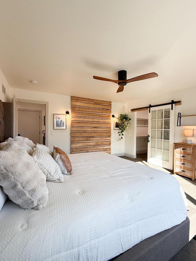 bedroom with carpet floors, a barn door, and ceiling fan