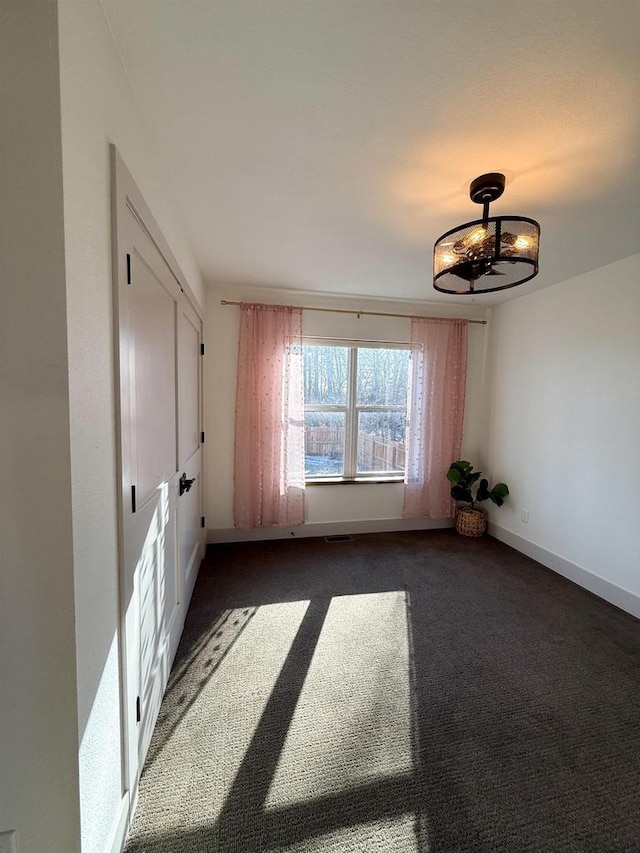 unfurnished room with dark carpet