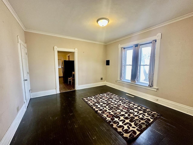 unfurnished room featuring dark wood-type flooring and crown molding