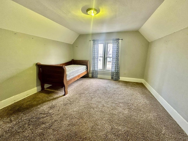 unfurnished bedroom with lofted ceiling, carpet floors, and a textured ceiling