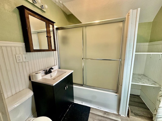 full bathroom with vanity, hardwood / wood-style floors, toilet, and combined bath / shower with glass door