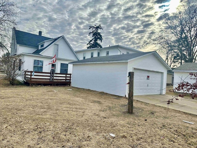 exterior space featuring a garage, a front lawn, and a deck