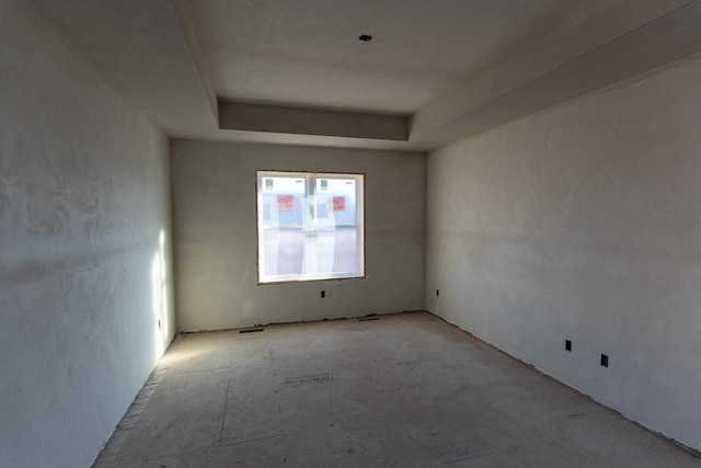 unfurnished room featuring a tray ceiling