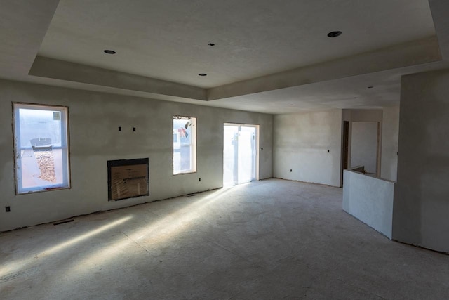 unfurnished living room featuring a tray ceiling