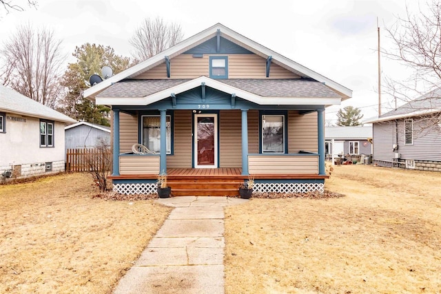 bungalow-style home featuring covered porch and a front lawn