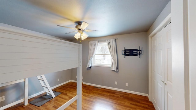 workout room with hardwood / wood-style floors and ceiling fan