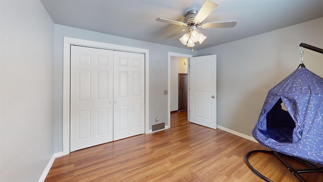 interior space with hardwood / wood-style floors, ceiling fan, and a closet