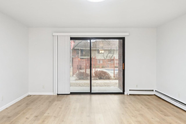 unfurnished room featuring a baseboard radiator and light hardwood / wood-style floors