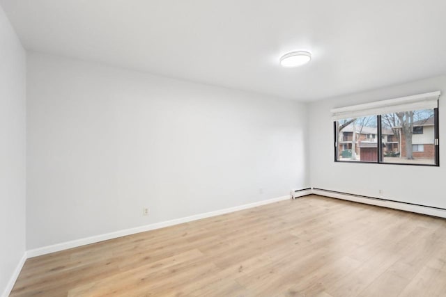 spare room featuring a baseboard radiator and light wood-type flooring