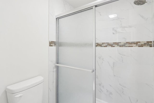 bathroom featuring an enclosed shower and toilet