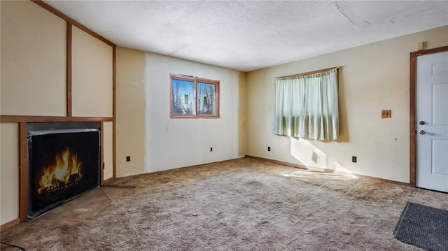 unfurnished living room with light colored carpet and a textured ceiling