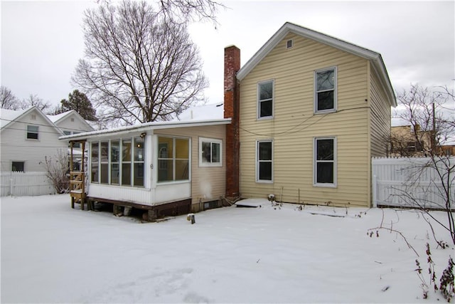 snow covered property with a sunroom