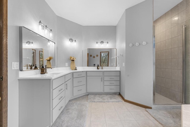 bathroom featuring vanity, a tile shower, and tile patterned floors