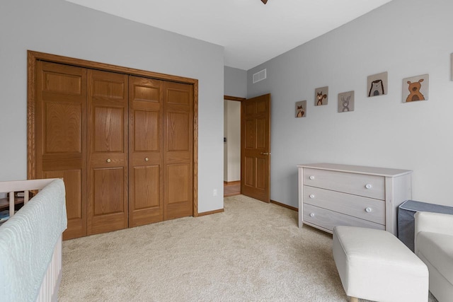 bedroom featuring light colored carpet and a closet