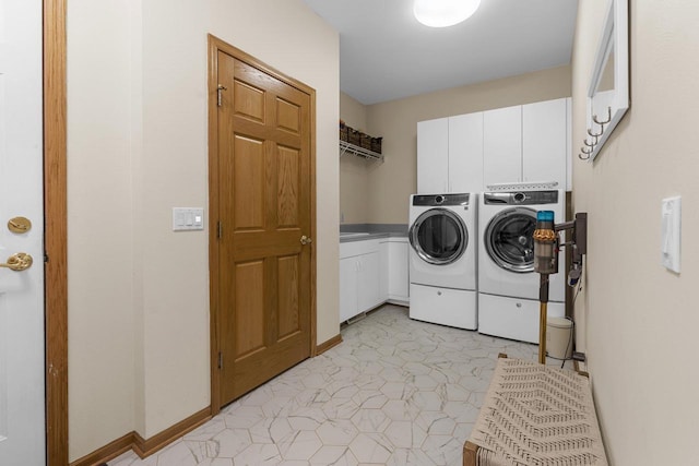 laundry area with separate washer and dryer and cabinets