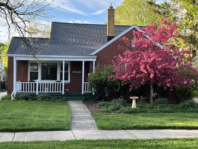 view of front of home with a porch and a front lawn