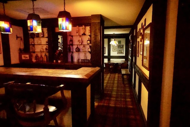 bar with butcher block counters and hanging light fixtures