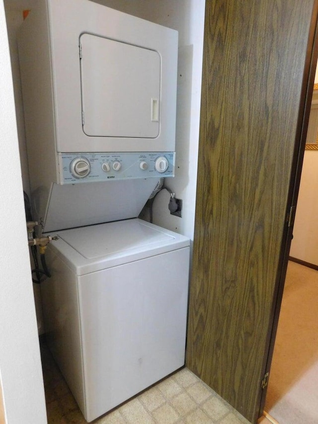 clothes washing area with stacked washer / dryer