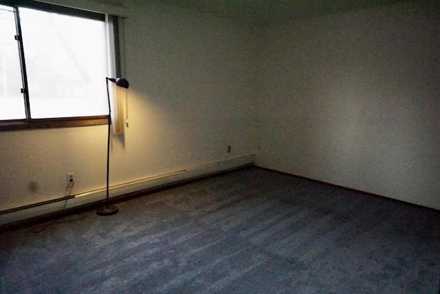 unfurnished room featuring wood-type flooring and a baseboard radiator