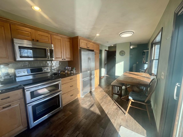 kitchen featuring stainless steel appliances, dark hardwood / wood-style floors, and decorative backsplash