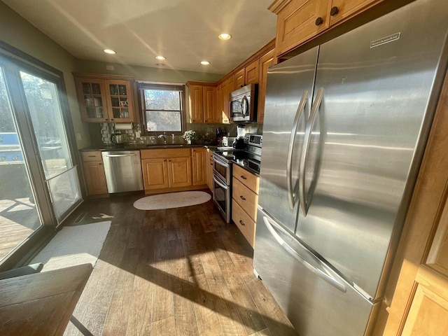 kitchen with dark wood-type flooring, appliances with stainless steel finishes, sink, and decorative backsplash