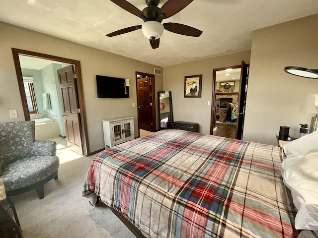 carpeted bedroom featuring ceiling fan and ensuite bath