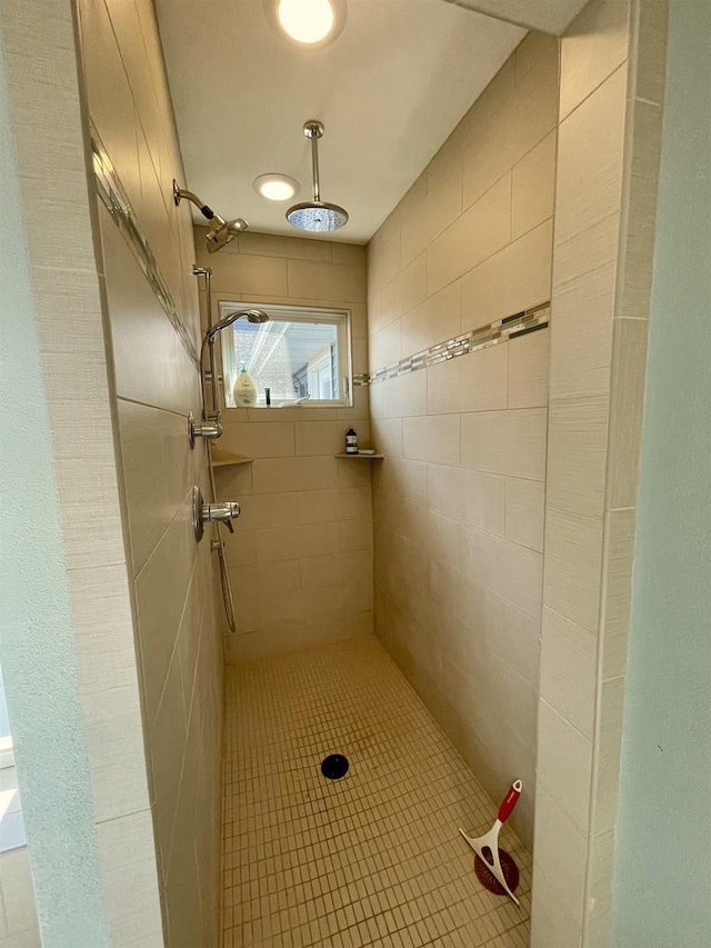 bathroom featuring tile patterned flooring and a tile shower