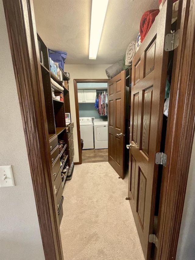 spacious closet with independent washer and dryer and light carpet