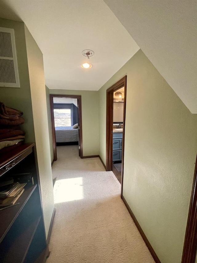 hall with vaulted ceiling and light carpet