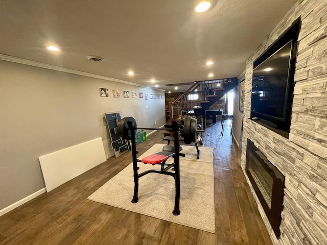 workout room featuring ornamental molding and dark hardwood / wood-style flooring