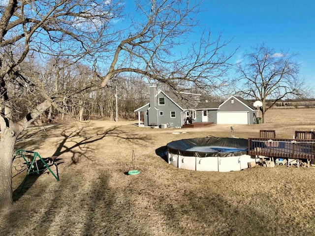 view of yard featuring a garage and a covered pool